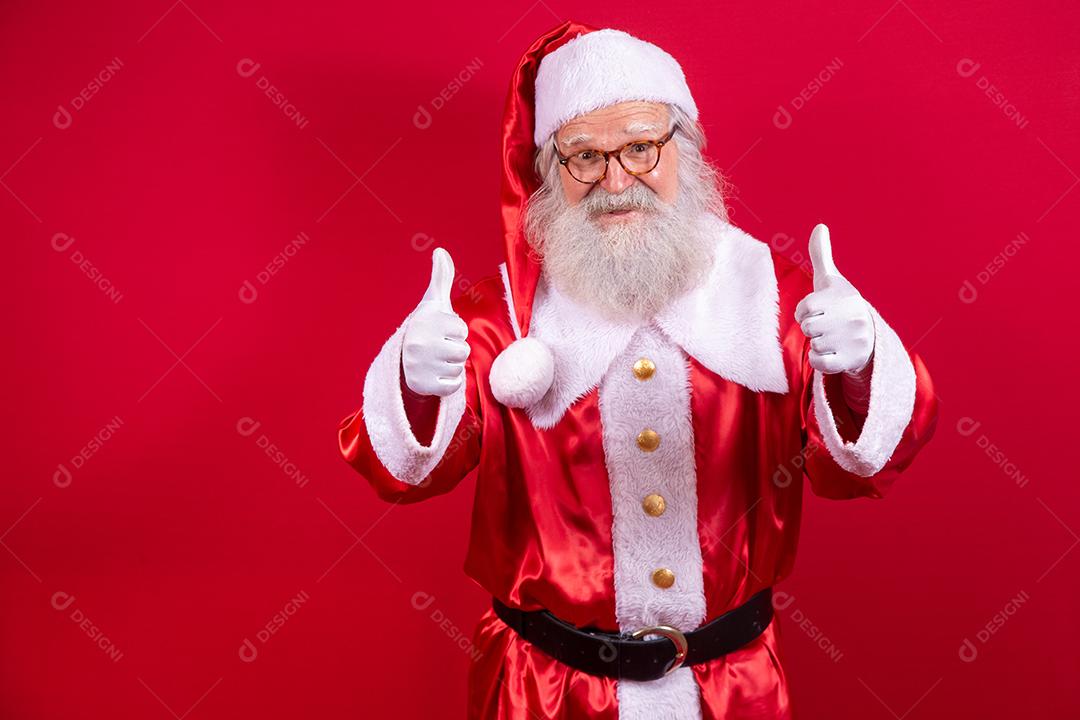 Papai Noel mostrando o polegar para cima. Papai Noel com barba real e grande sorriso dando o polegar para cima.
