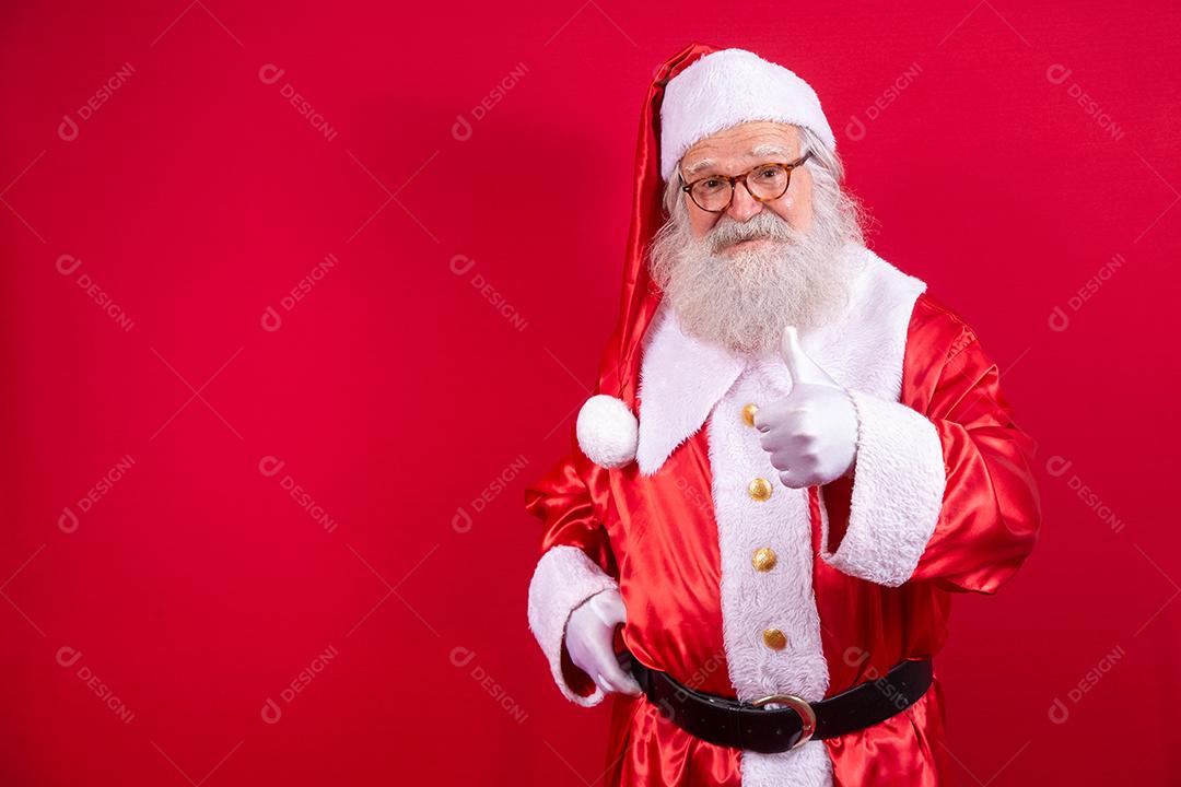 Papai Noel mostrando o polegar para cima. Papai Noel com barba real e grande sorriso dando o polegar para cima.