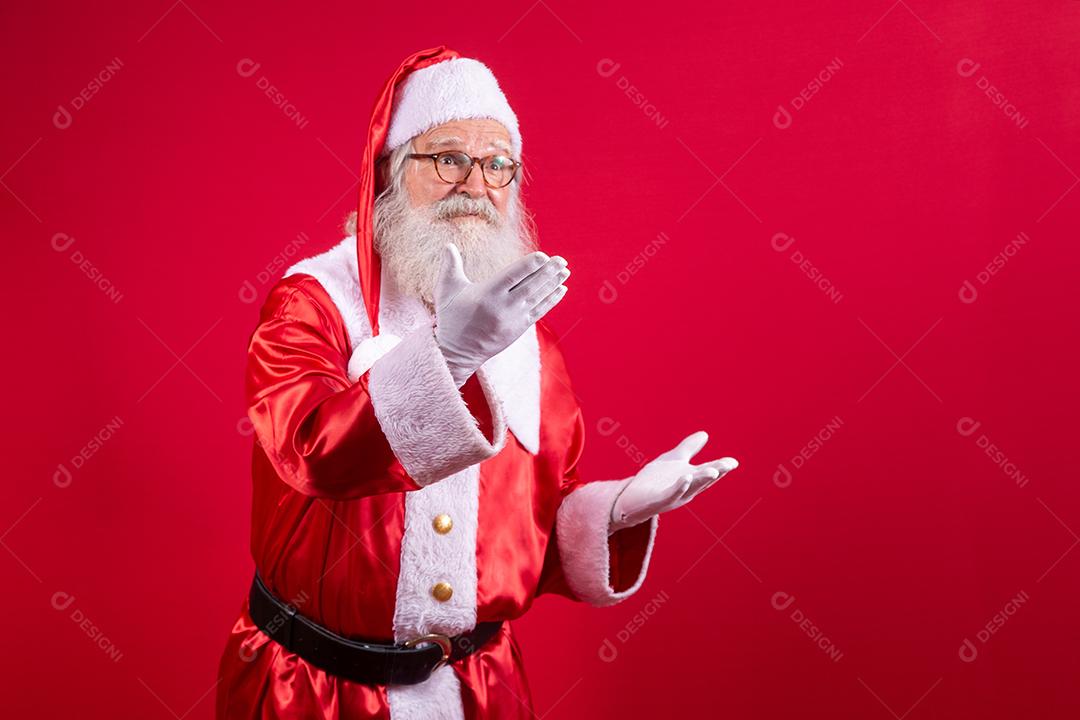 Papai Noel apontando de lado, promoção de publicidade de Natal, anúncio de desconto de Natal de ano novo isolado em fundo vermelho.