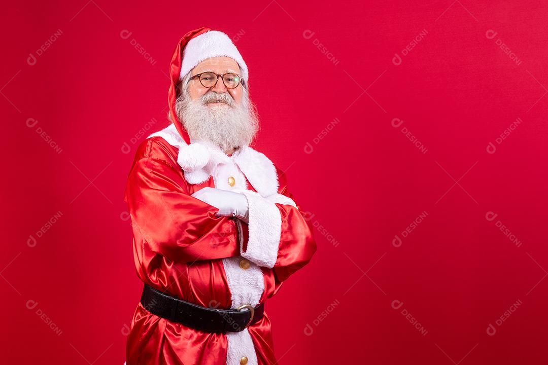 Papai Noel cruzou os braços sobre fundo vermelho. Tipo barbudo Papai Noel com os braços cruzados