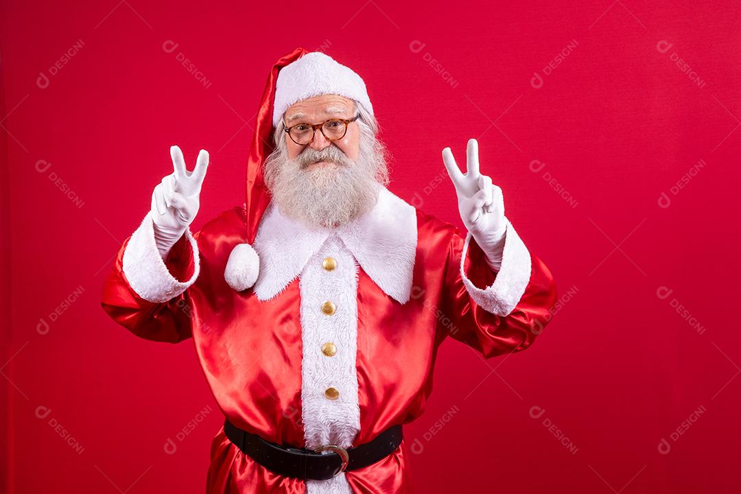 Papai Noel fazendo o sinal V na foto. Papai Noel fazendo um sinal de paz e amor e expressão facial