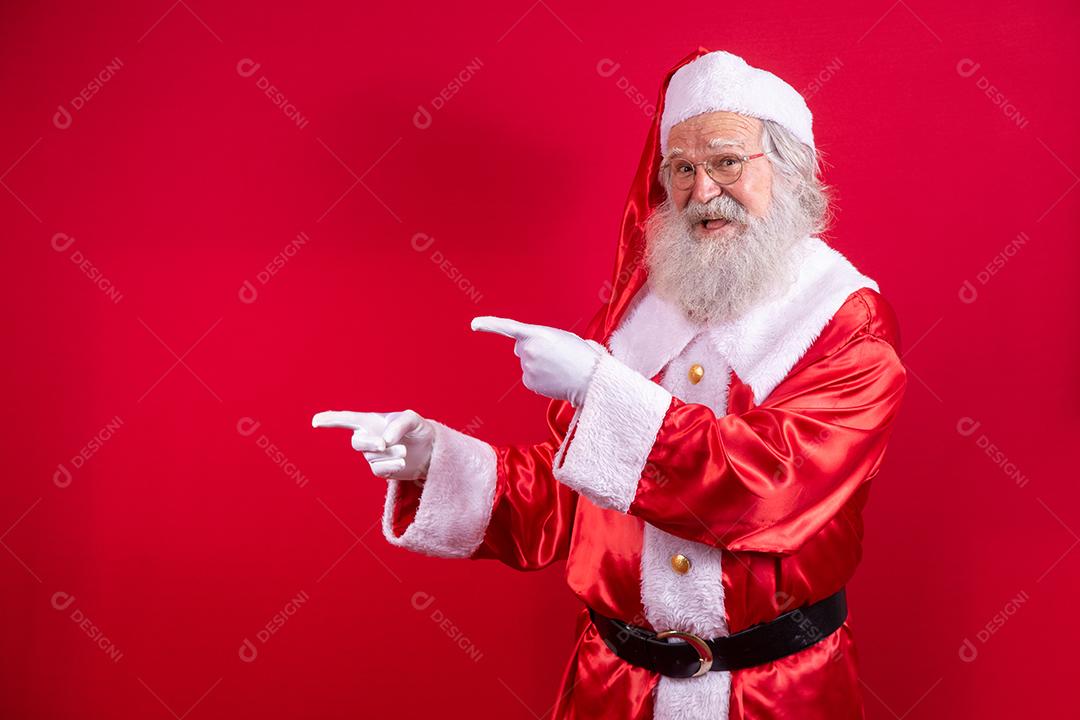 Engraçado feliz animado velho barbudo rosto de Papai Noel vestindo traje olhando para a câmera mostrando