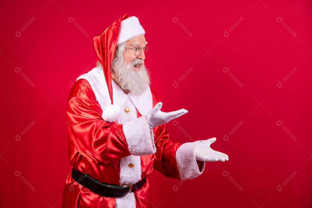 Papai Noel apontando de lado, promoção de publicidade de Natal, anúncio de desconto de Natal de ano novo isolado em fundo vermelho.