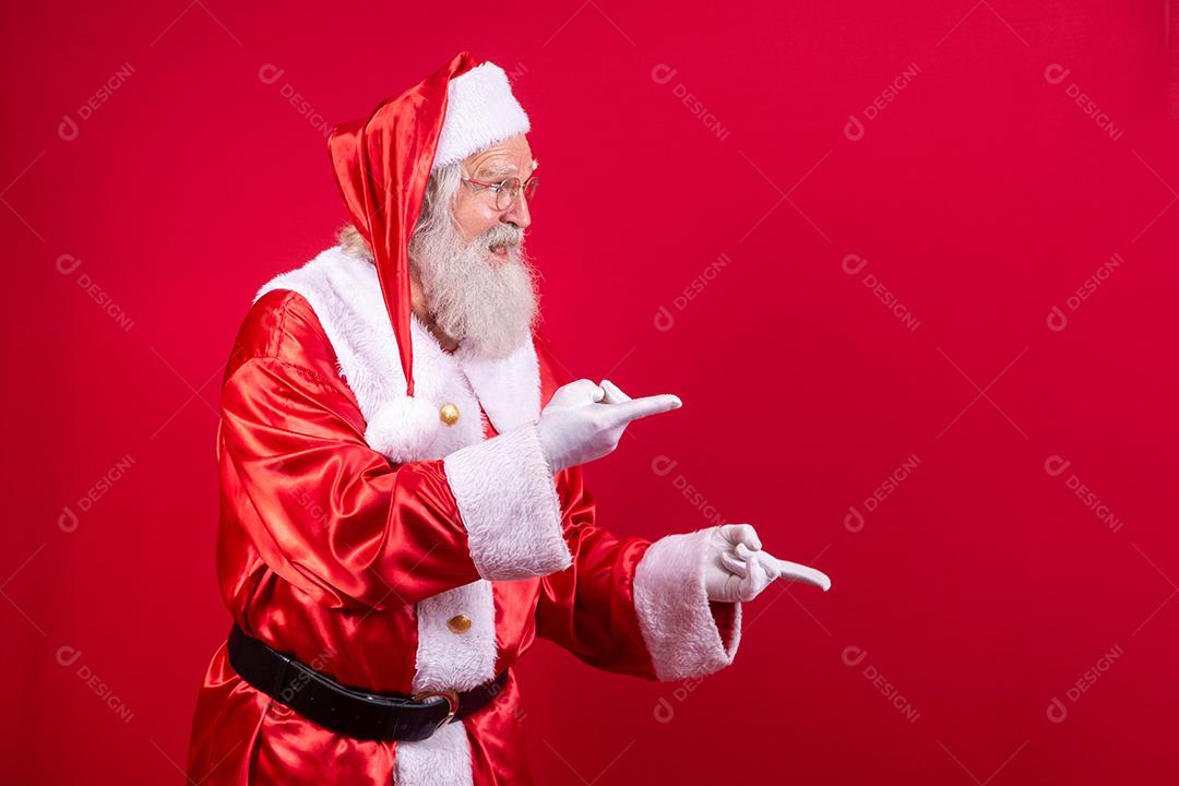 Papai Noel apontando de lado, promoção de publicidade de Natal, anúncio de desconto de Natal de ano novo isolado em fundo vermelho.