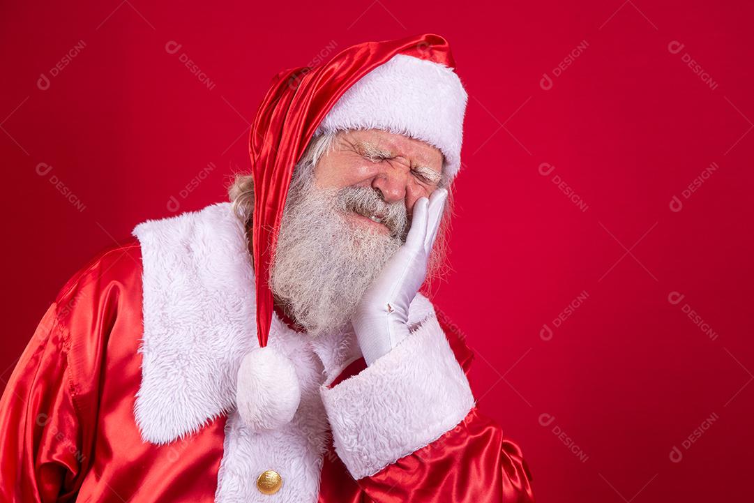 Papai Noel com a mão sobre a boca com expressão de dor por causa de dor de dente ou doença dentária nos dentes