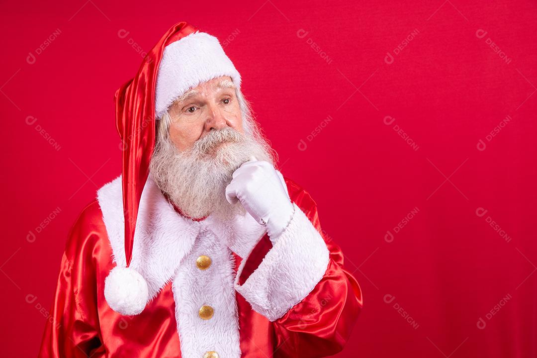 Pensativo Papai Noel sobre fundo vermelho. verdadeiro Papai Noel pensando