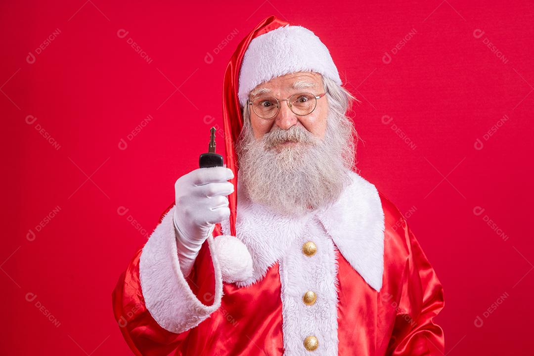 Papai Noel segurando as chaves de um carro em fundo vermelho