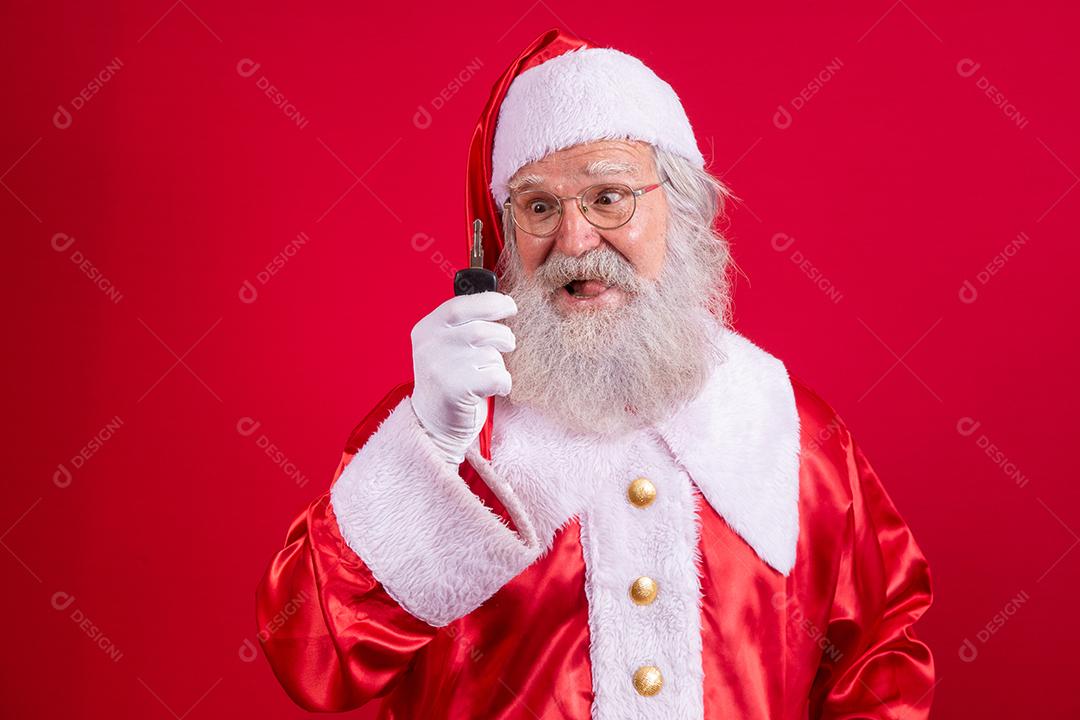 Papai Noel segurando as chaves de um carro em fundo vermelho