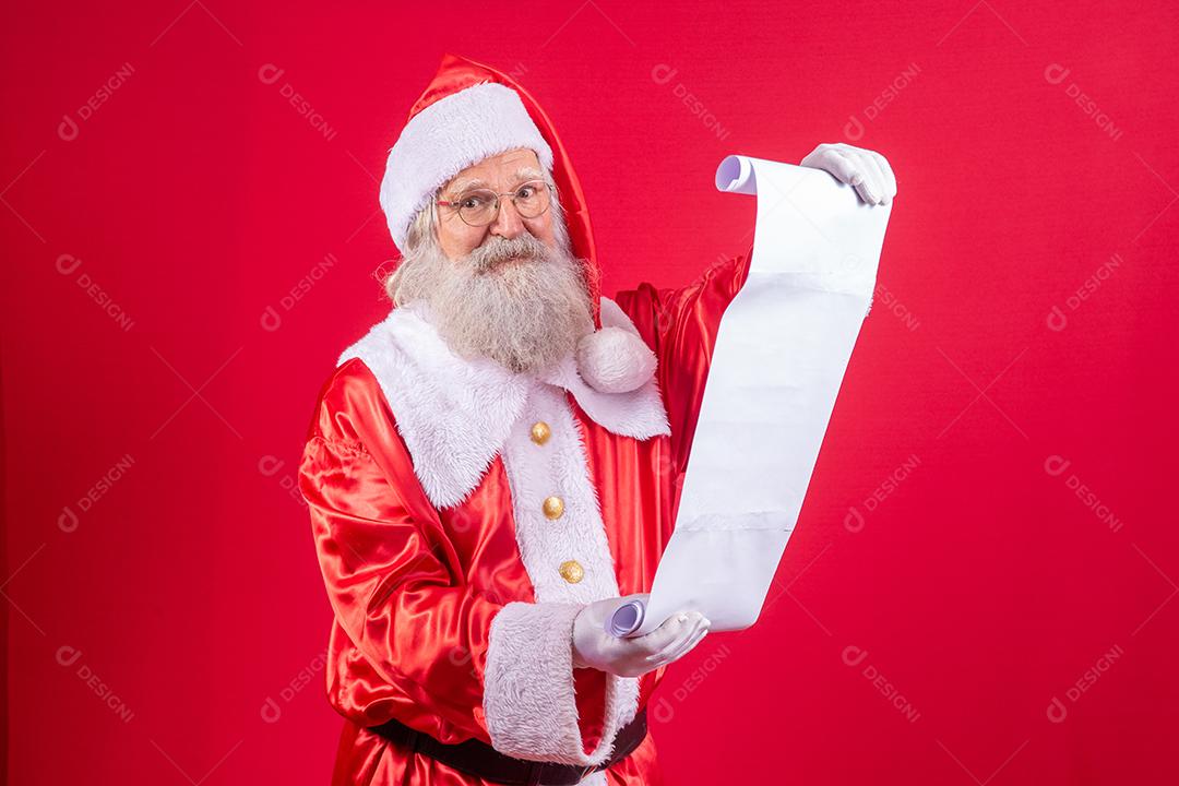 Retrato de feliz Papai Noel lendo carta de Natal ou lista de desejos.