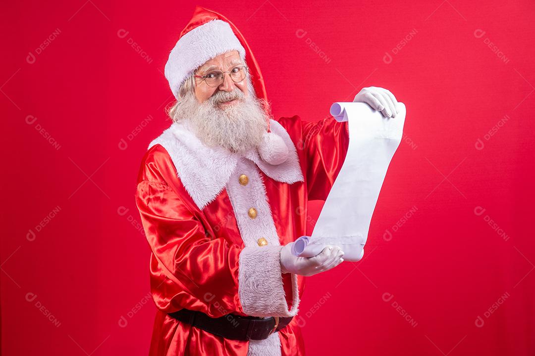Retrato de feliz Papai Noel lendo carta de Natal ou lista de desejos.