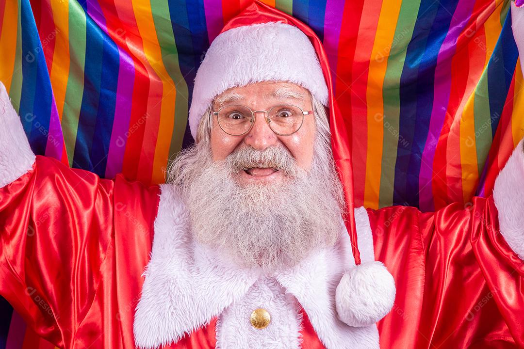 Papai Noel cobrindo com bandeira do orgulho LGBT. Sozinho. Um. Mantendo o punho erguido, cobrindo a bandeira LGBT. Bandeira LGBT + em fundo vermelho. Natal.