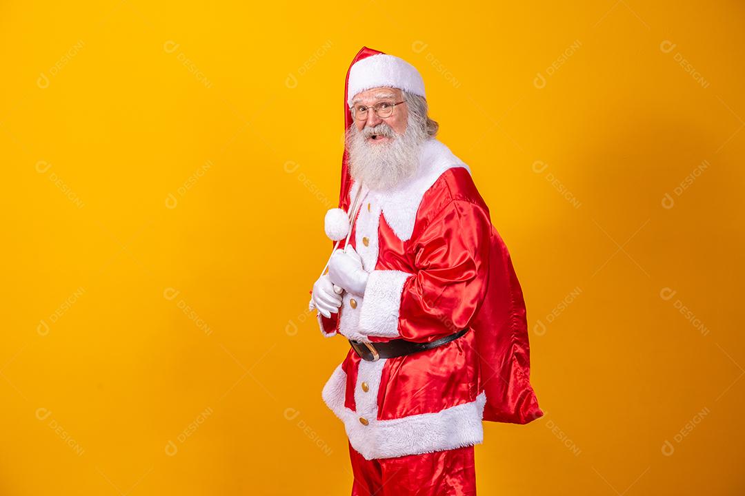 Verdadeiro Papai Noel com um fundo vermelho, usando óculos, luvas e um chapéu olhando de lado.