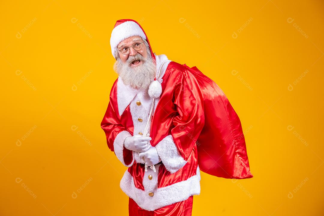Verdadeiro Papai Noel com um fundo vermelho, usando óculos, luvas e um chapéu olhando de lado.