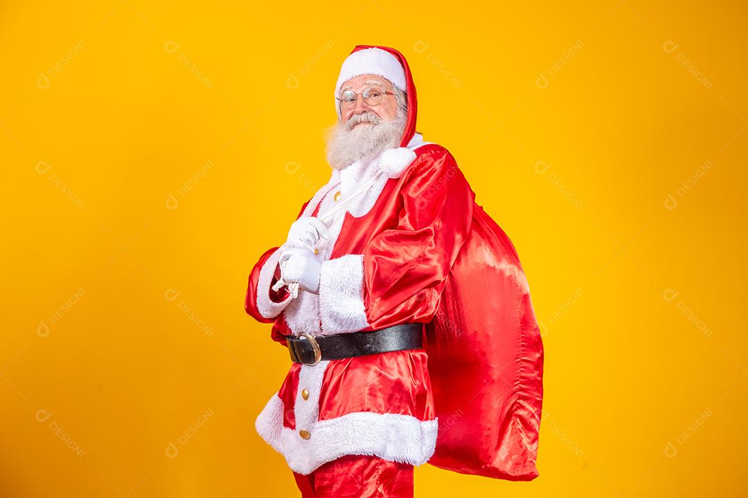 Verdadeiro Papai Noel com um fundo vermelho, usando óculos, luvas e um chapéu olhando de lado.