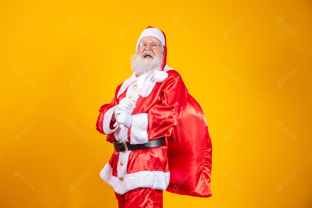 Verdadeiro Papai Noel com um fundo vermelho, usando óculos, luvas e um chapéu olhando de lado.