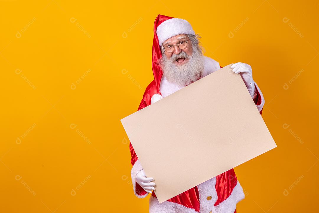 Feliz Papai Noel segurando uma placa em branco isolada em fundo amarelo