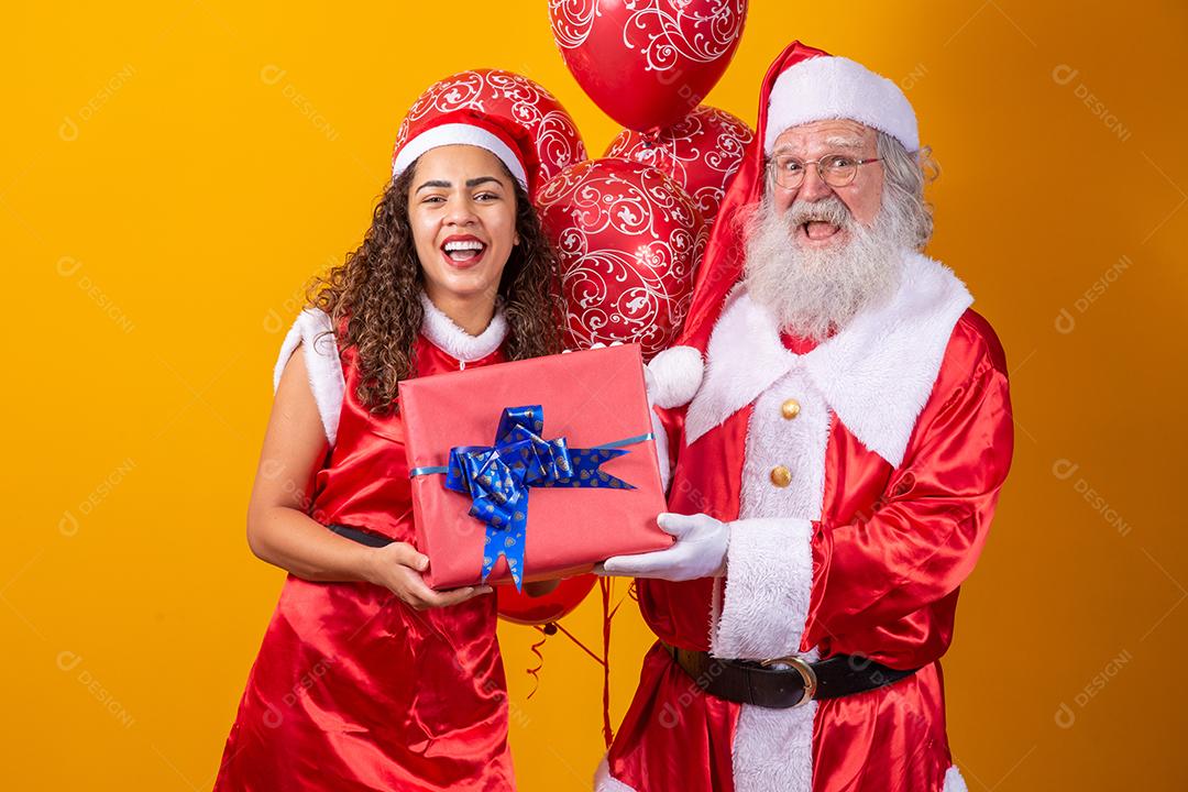 Real Santa com seu ajudante noelete segurando o presente de Natal da criança