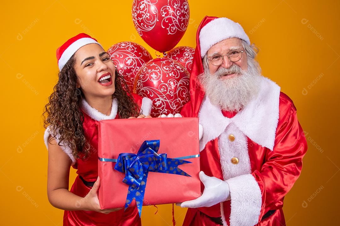 Real Santa com seu ajudante noelete segurando o presente de Natal da criança