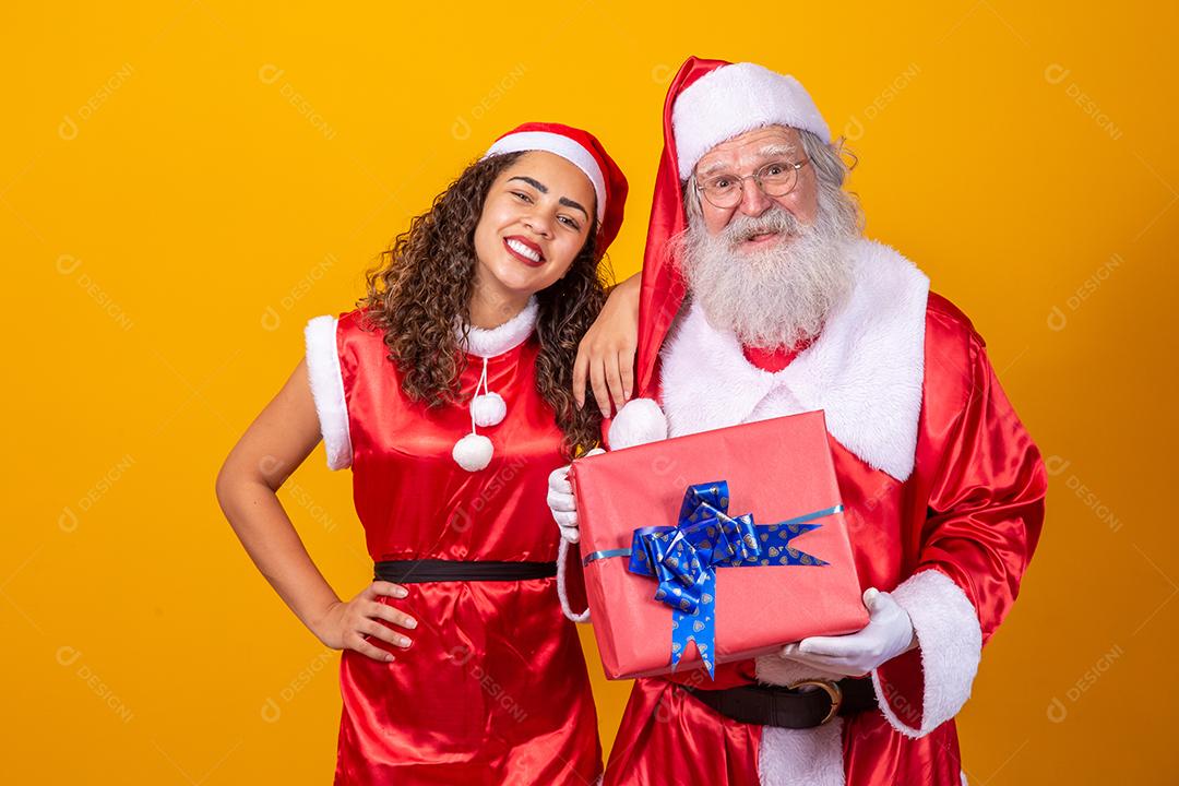 Real Santa com seu ajudante noelete segurando o presente de Natal da criança