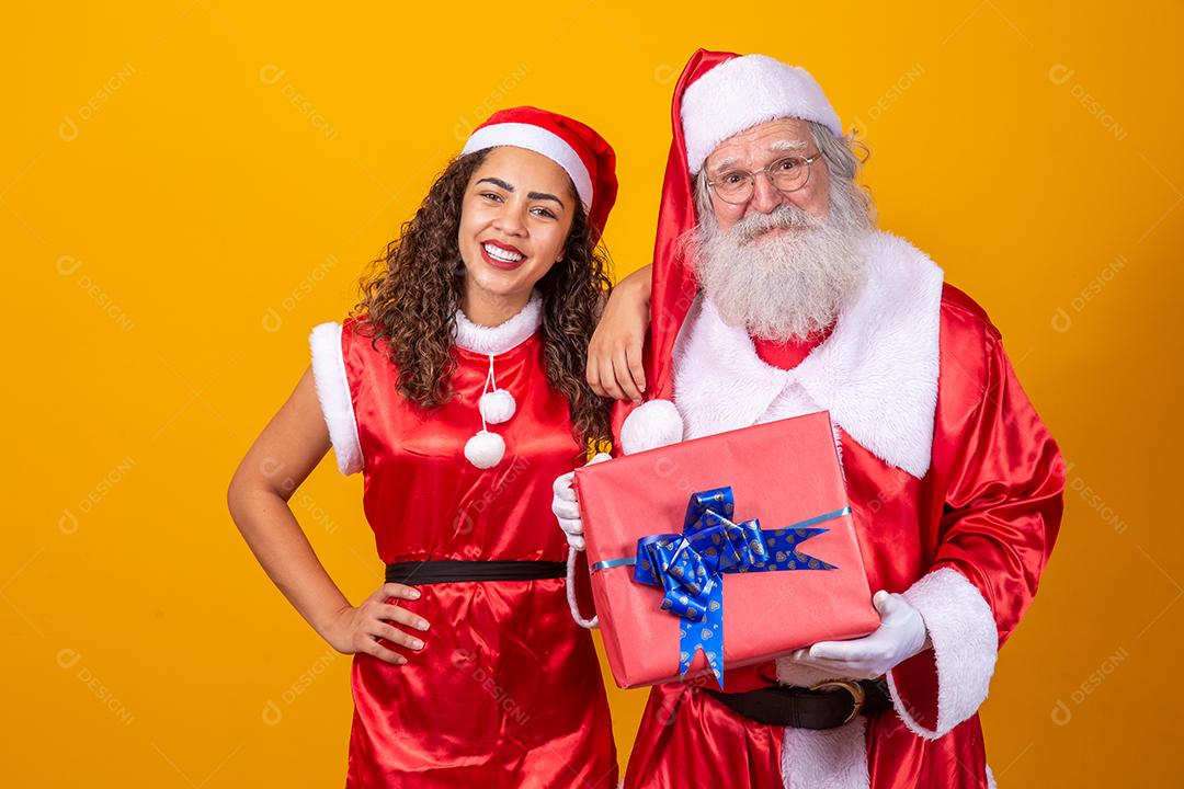 Real Santa com seu ajudante noelete segurando o presente de Natal da criança