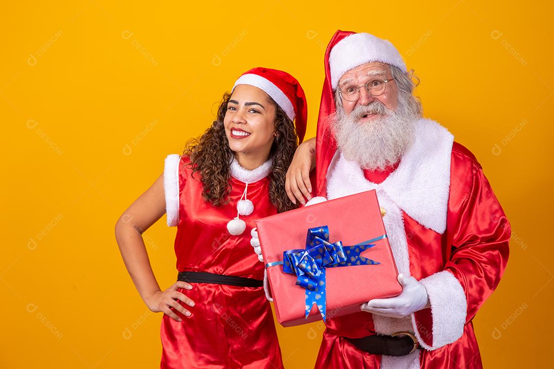 Real Santa com seu ajudante noelete segurando o presente de Natal da criança