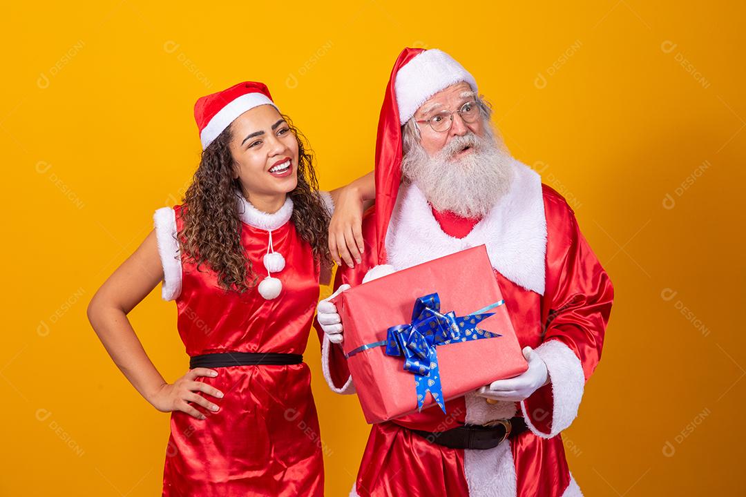 Real Santa com seu ajudante noelete segurando o presente de Natal da criança