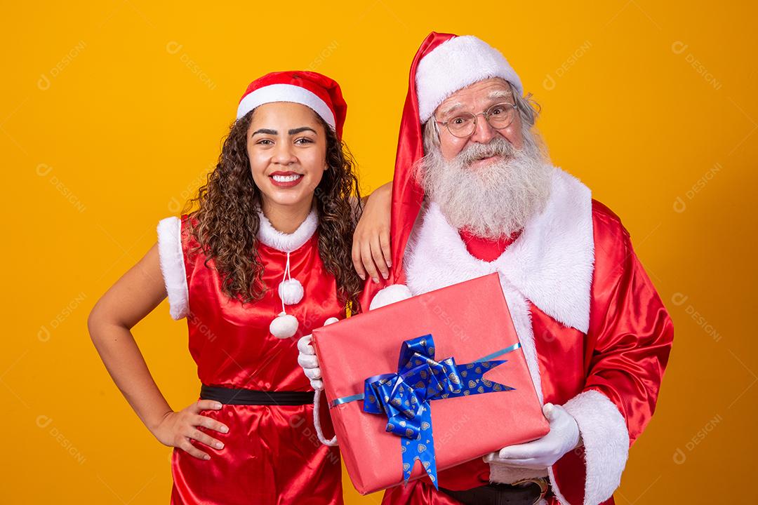 Real Santa com seu ajudante noelete segurando o presente de Natal da criança