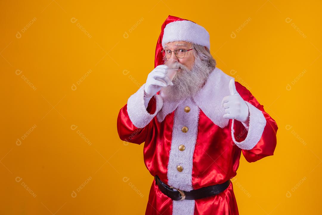 Papai Noel tomando um café em fundo amarelo com espaço livre