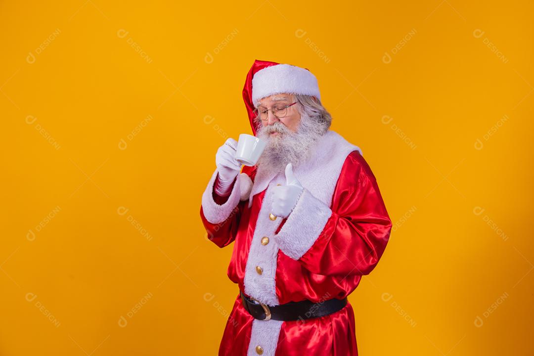 Papai Noel tomando um café em fundo amarelo com espaço livre