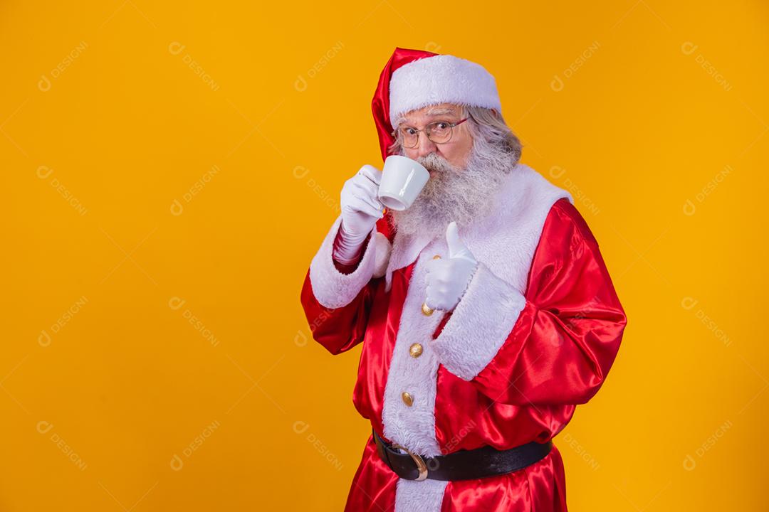 Papai Noel tomando um café em fundo amarelo com espaço livre