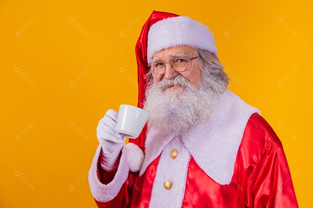 Papai Noel tomando um café em fundo amarelo com espaço livre