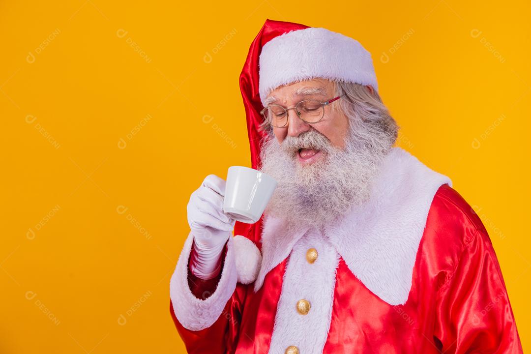 Papai Noel tomando um café em fundo amarelo com espaço livre