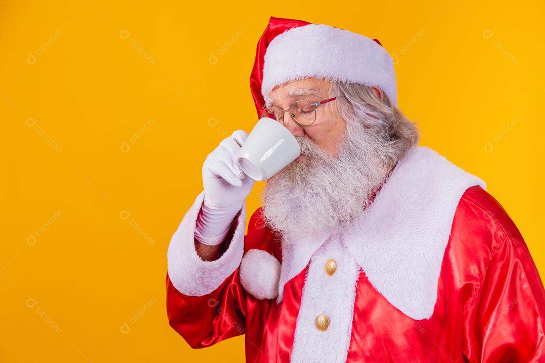 Papai Noel tomando um café em fundo amarelo com espaço livre