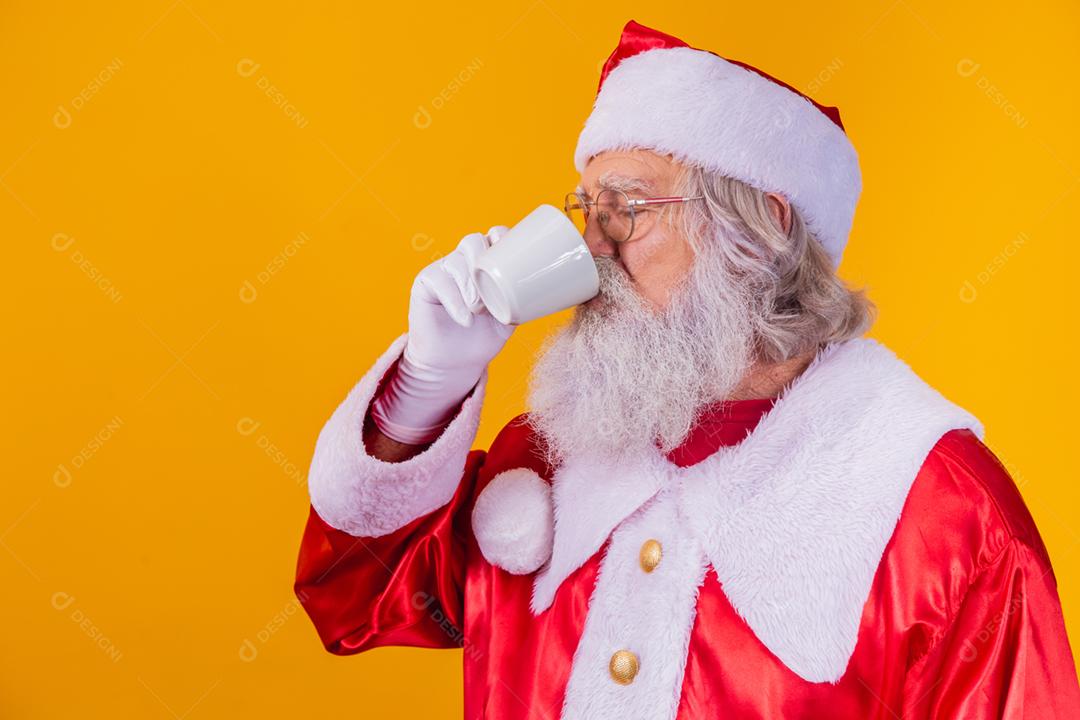 Papai Noel tomando um café em fundo amarelo com espaço livre
