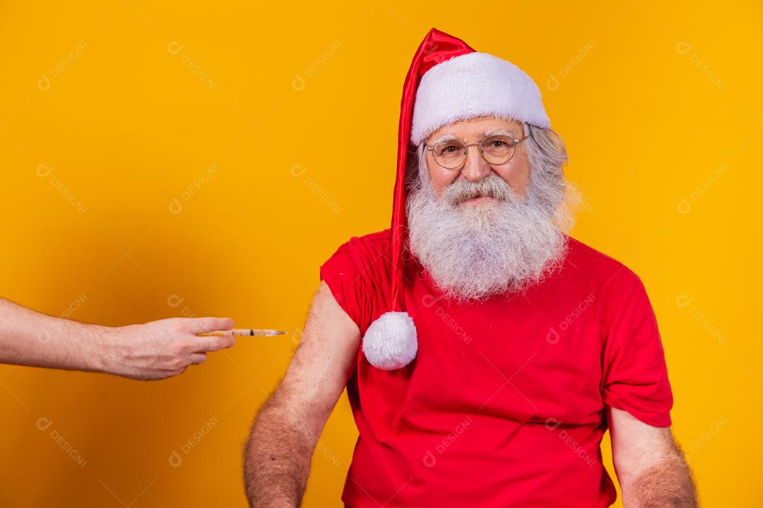 Papai Noel sendo vacinado com injeção.