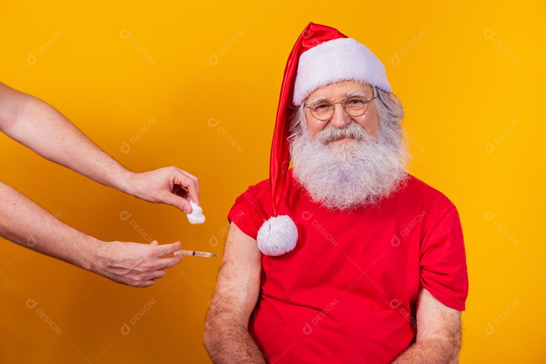 Papai Noel sendo vacinado com injeção.