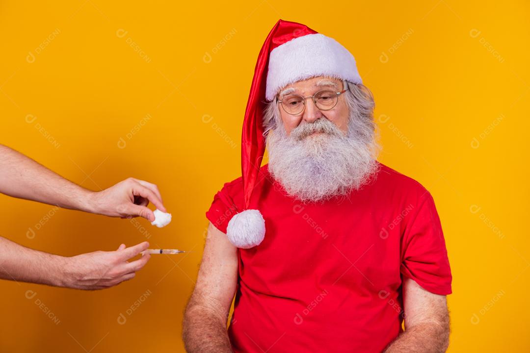 Papai Noel sendo vacinado com injeção.