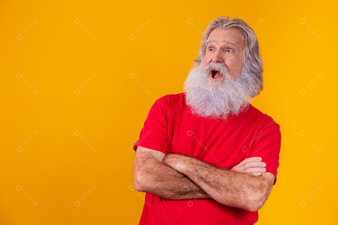 velho com barba longa com os braços cruzados, olhando para a câmera