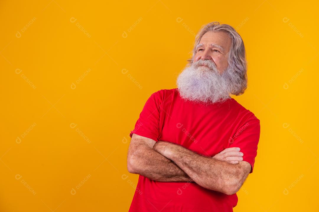 velho com barba longa com os braços cruzados, olhando para a câmera