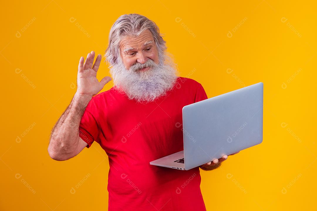 Homem em fundo amarelo fazendo uma chamada de vídeo no laptop