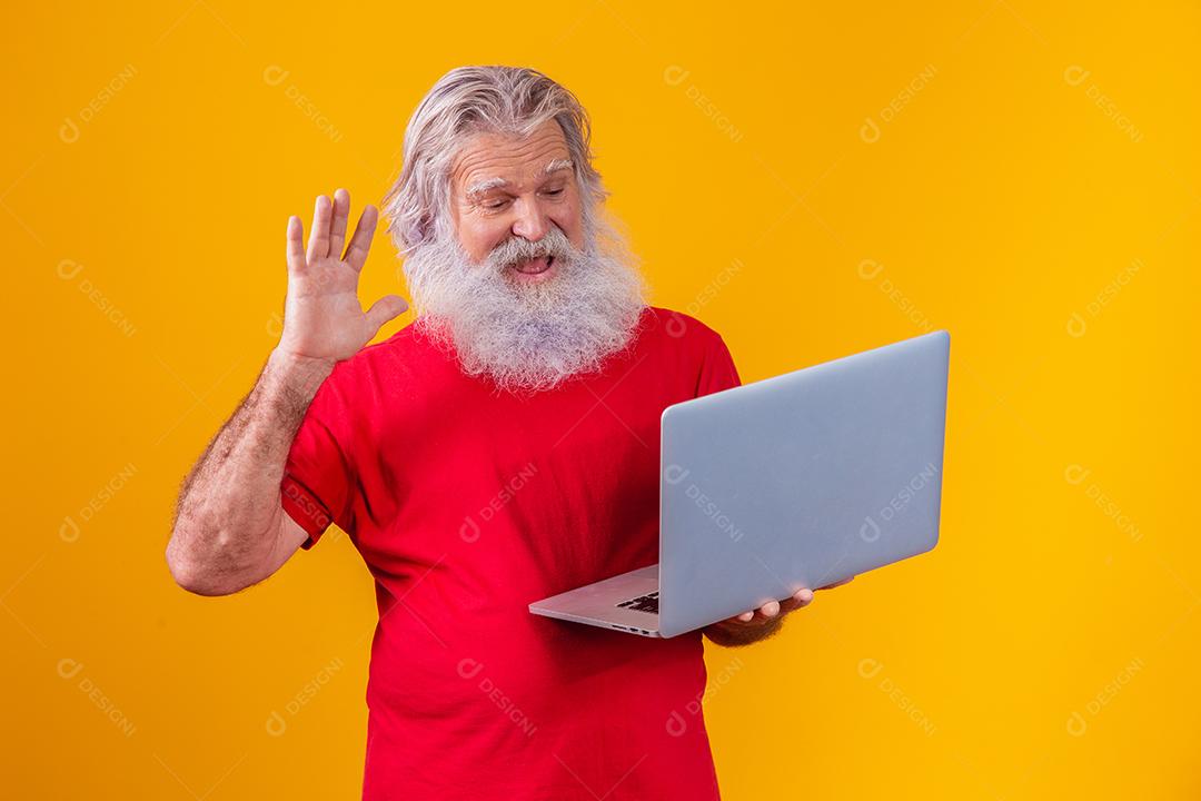 Homem em fundo amarelo fazendo uma chamada de vídeo no laptop