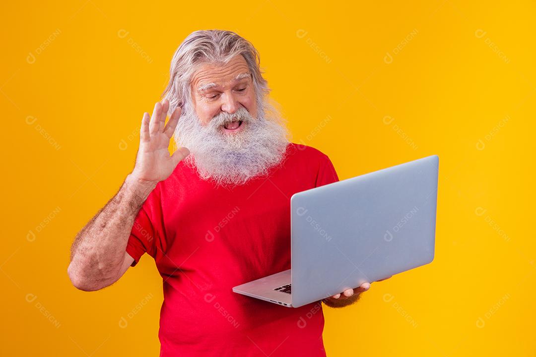 Homem em fundo amarelo fazendo uma chamada de vídeo no laptop