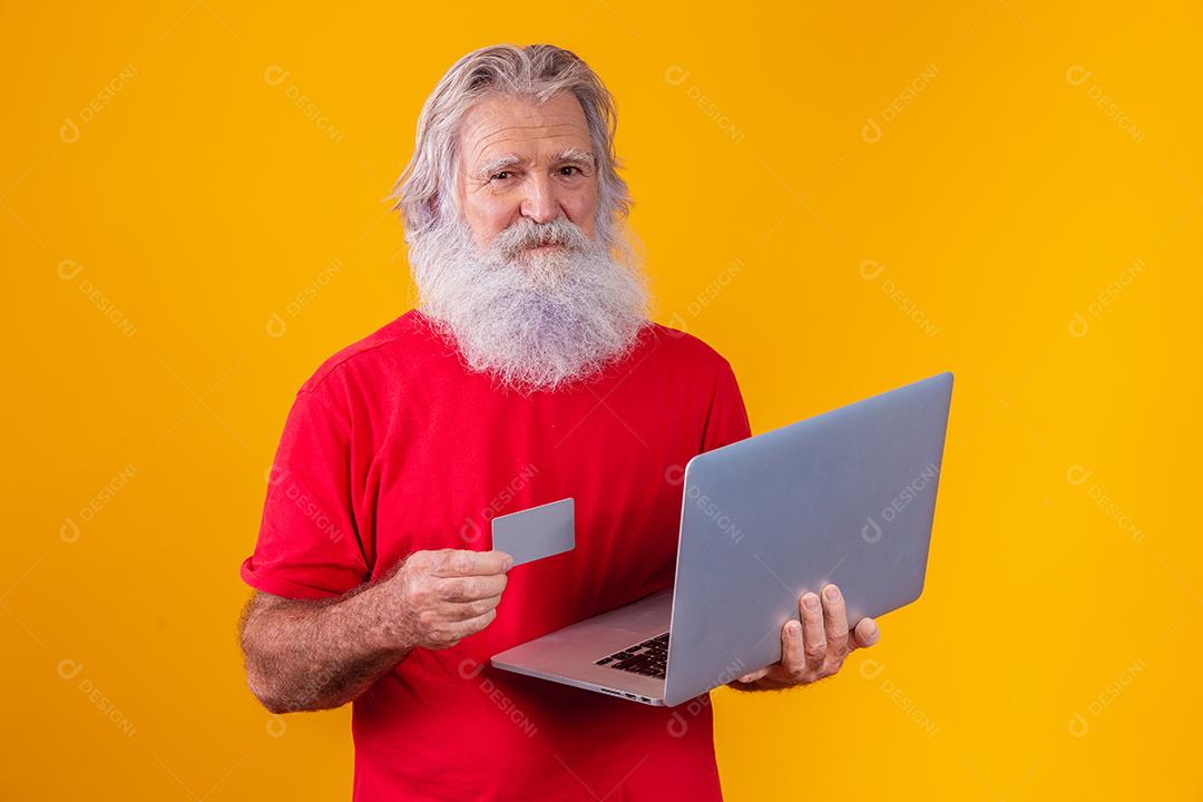 Homem idoso segurando computador portátil e cartão de crédito bancário. Transação de compras on-line. Método sem dinheiro de banco móvel.