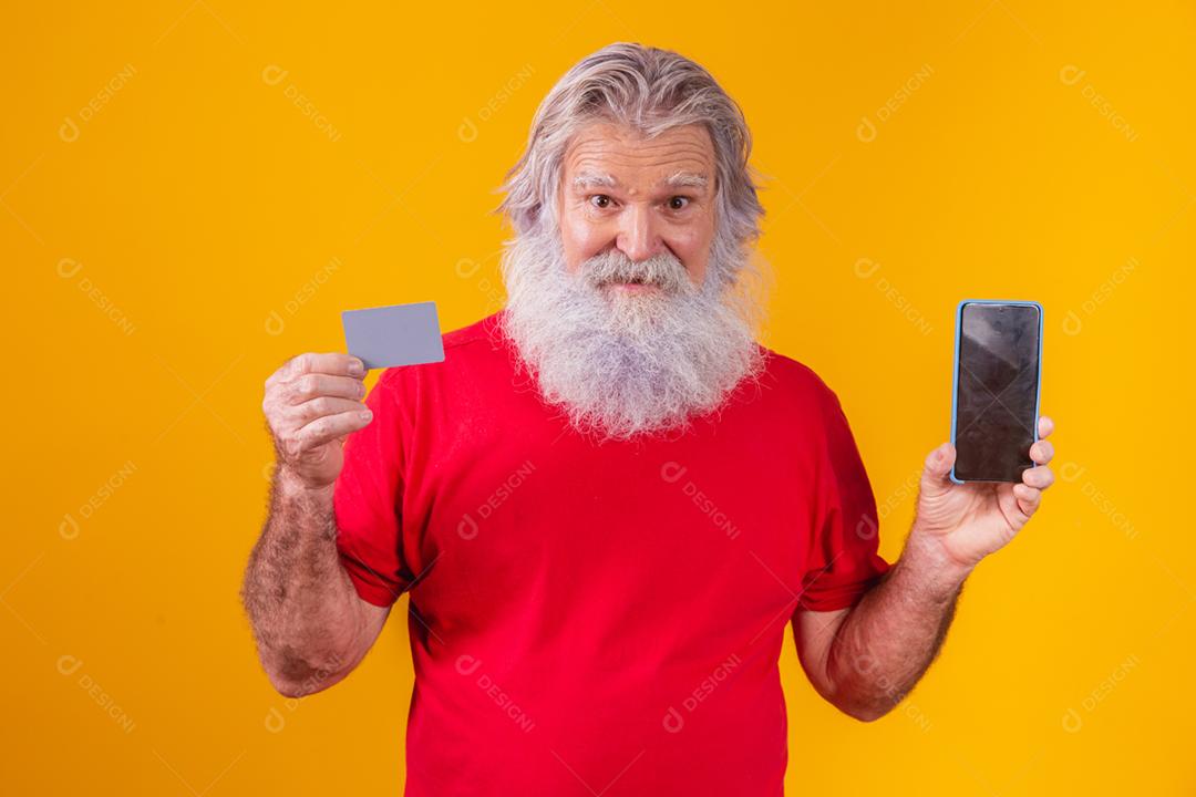 Retrato de um Papai Noel bonito segurando cartão de crédito e inteligente