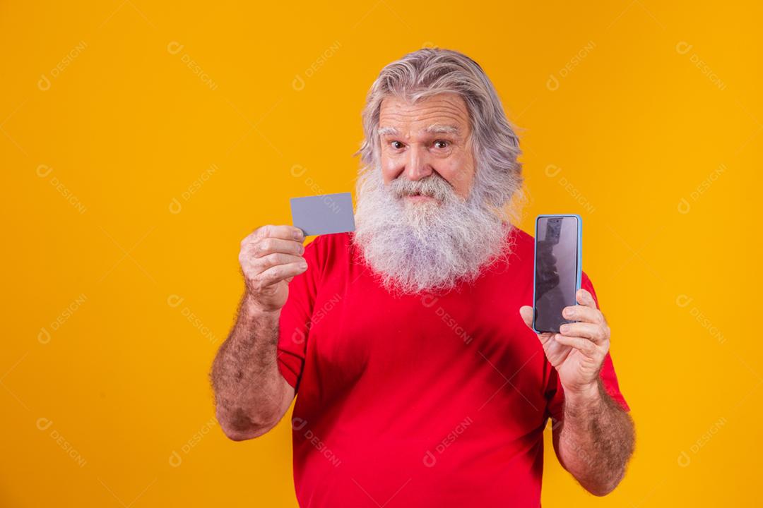 Retrato de um Papai Noel bonito segurando cartão de crédito e inteligente
