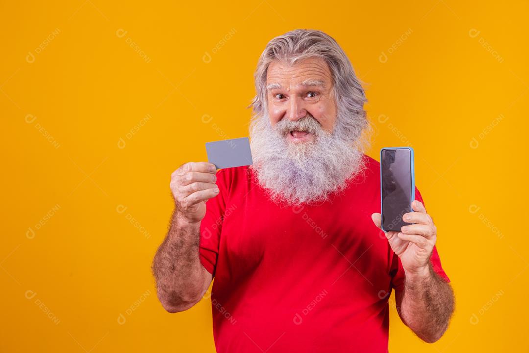Retrato de um Papai Noel bonito segurando cartão de crédito e inteligente