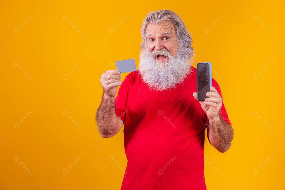Retrato de um Papai Noel bonito segurando cartão de crédito e inteligente