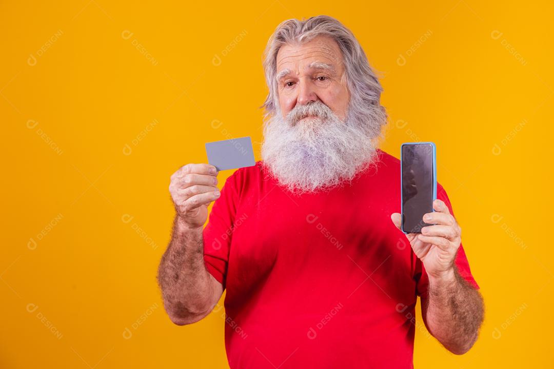 Retrato de um Papai Noel bonito segurando cartão de crédito e inteligente
