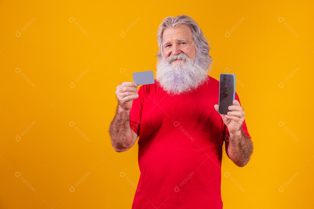 Retrato de um Papai Noel bonito segurando cartão de crédito e inteligente