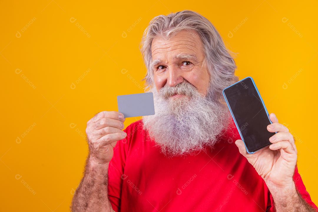 Retrato de um Papai Noel bonito segurando cartão de crédito e inteligente